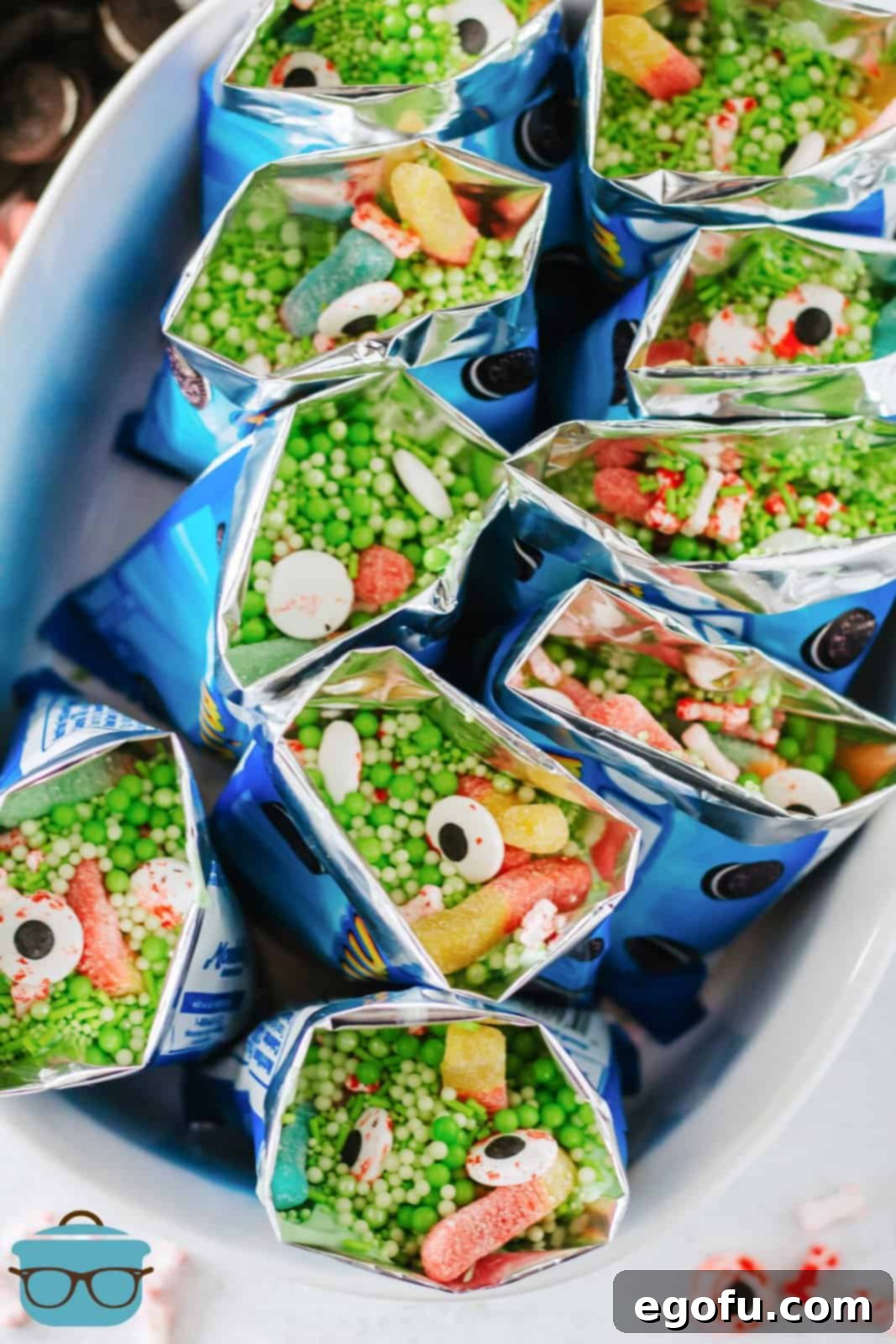 Overhead shot of completed Witches Brew Snack Bags presented in a white serving dish, ready for a Halloween party.