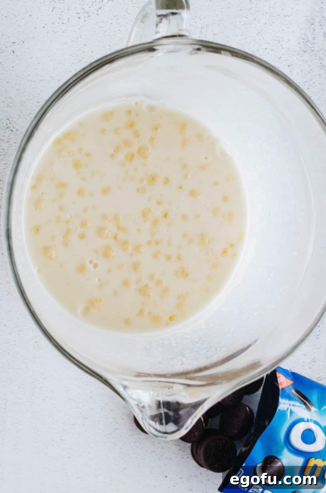 A bowl filled with freshly prepared, creamy pudding mixture, ready for the next step.