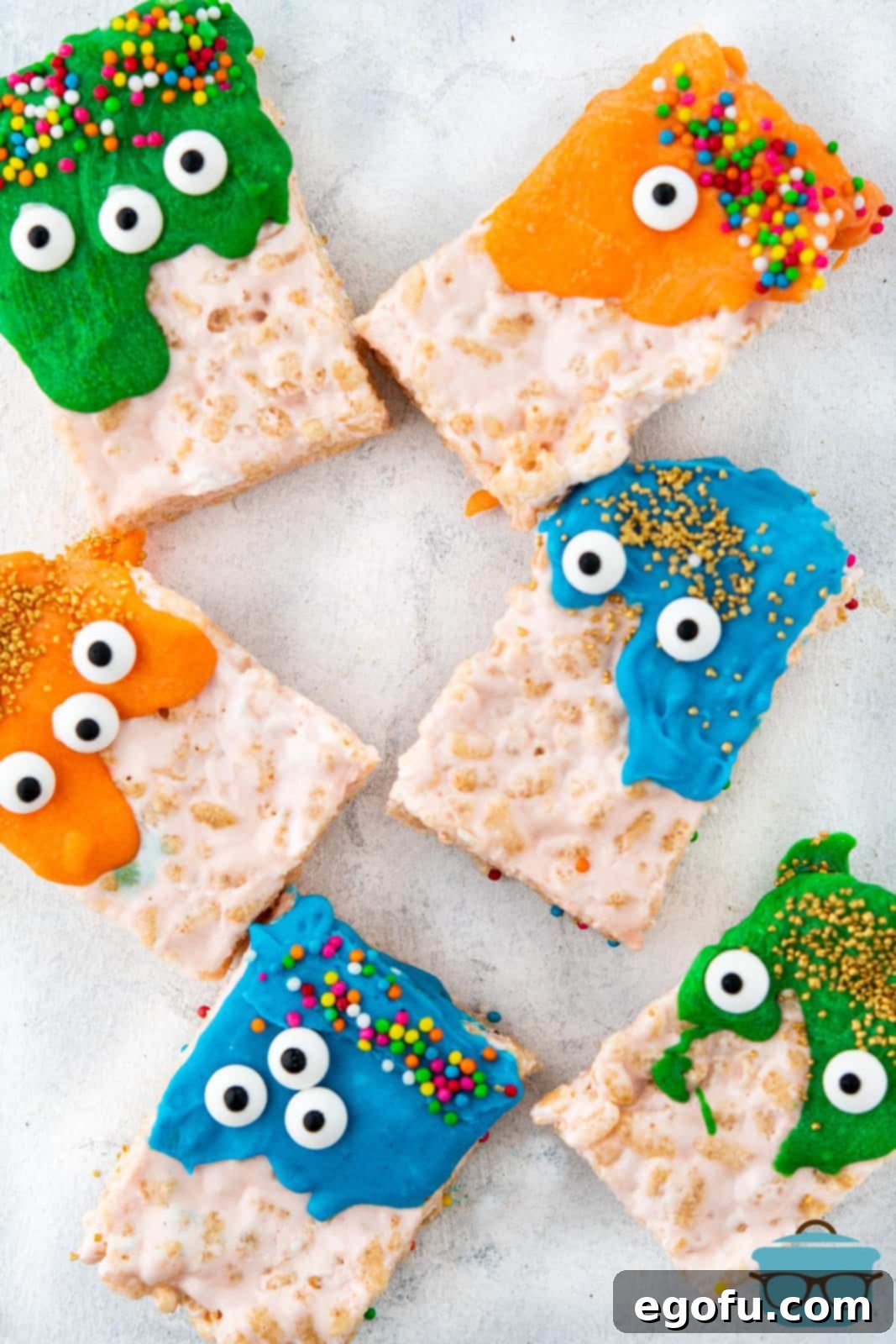 Creepy Crispy Critters 9 Overhead of decorated Halloween Rice Krispies Monsters on parchment paper.