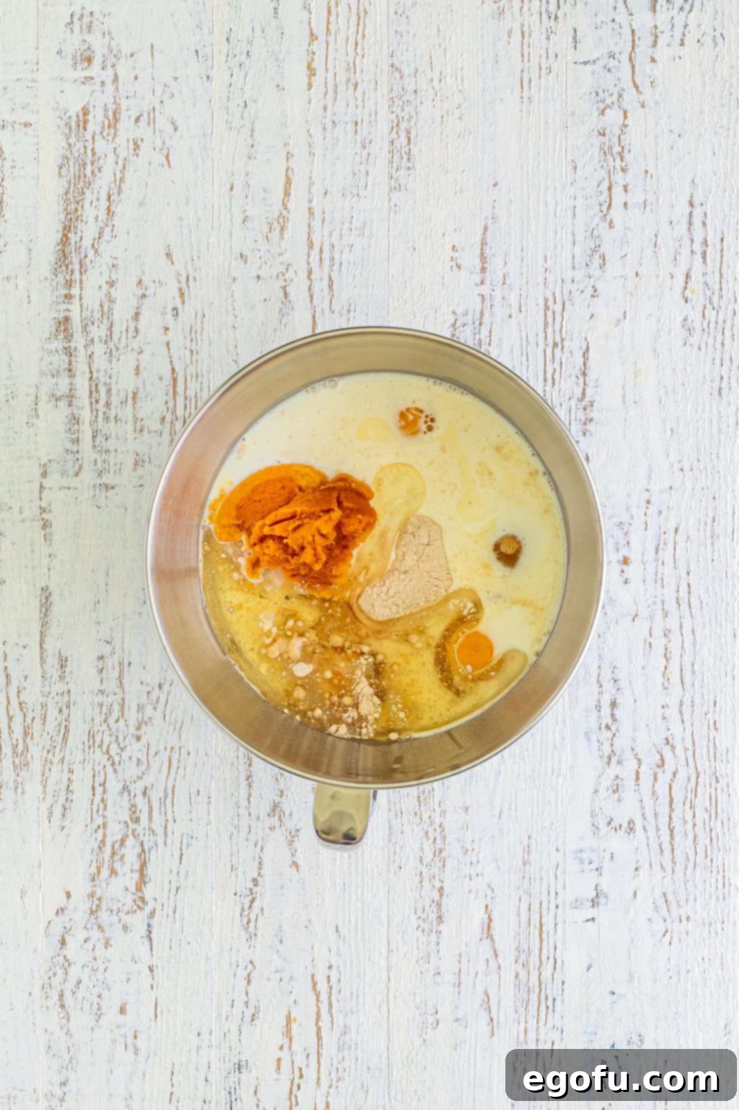 Cake ingredients added to bowl of stand mixer, ready for mixing.