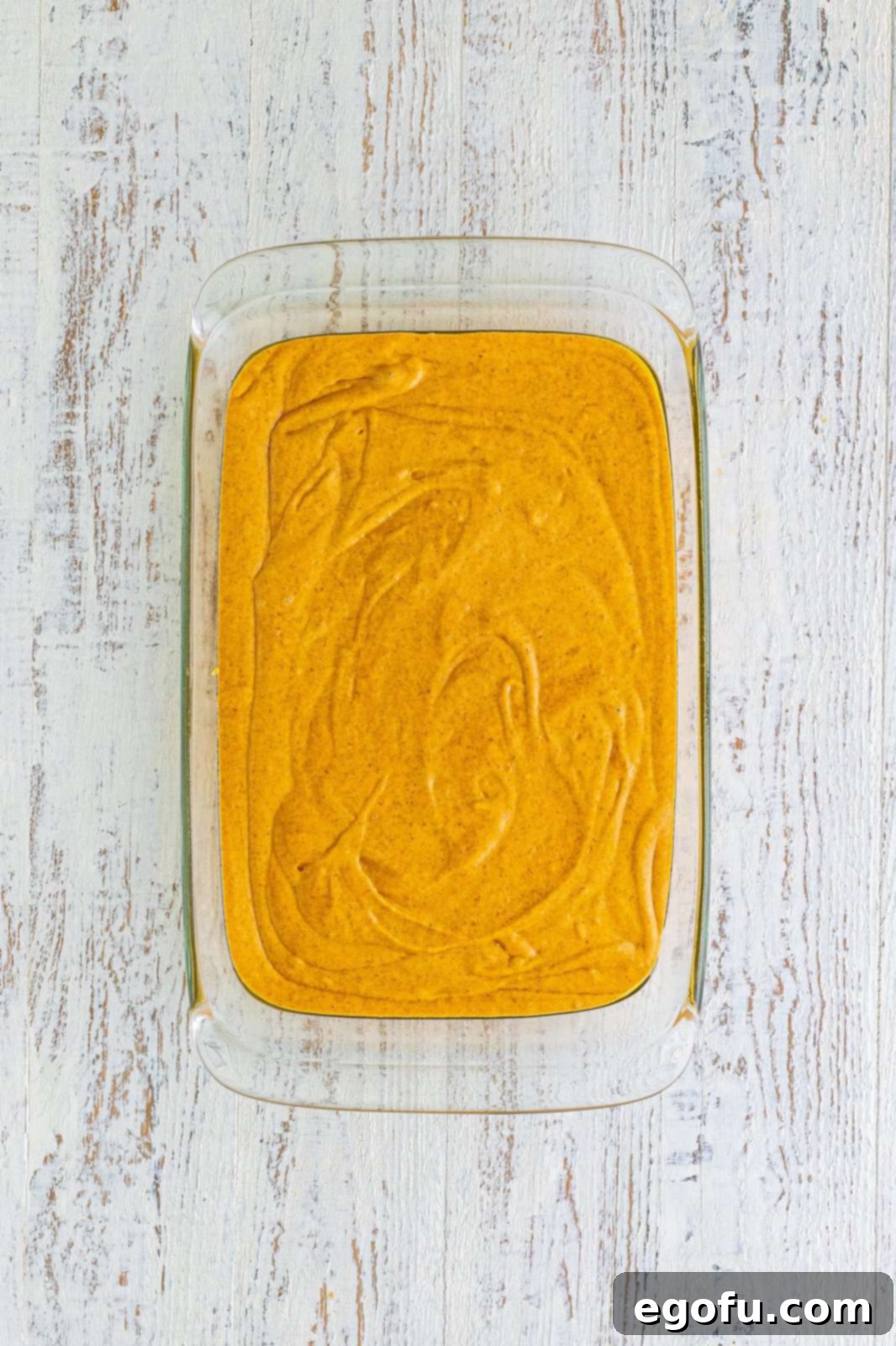 Cake batter poured into prepared baking pan, ready for the filling.