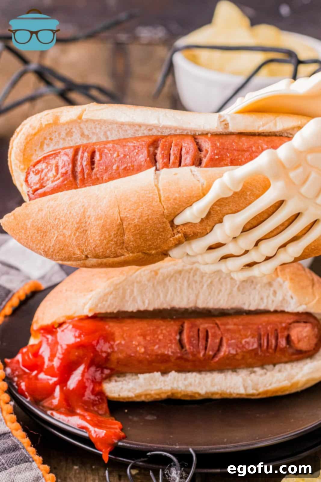 Halloween Hot Dog Fingers in buns with a skeleton hand holding one up.