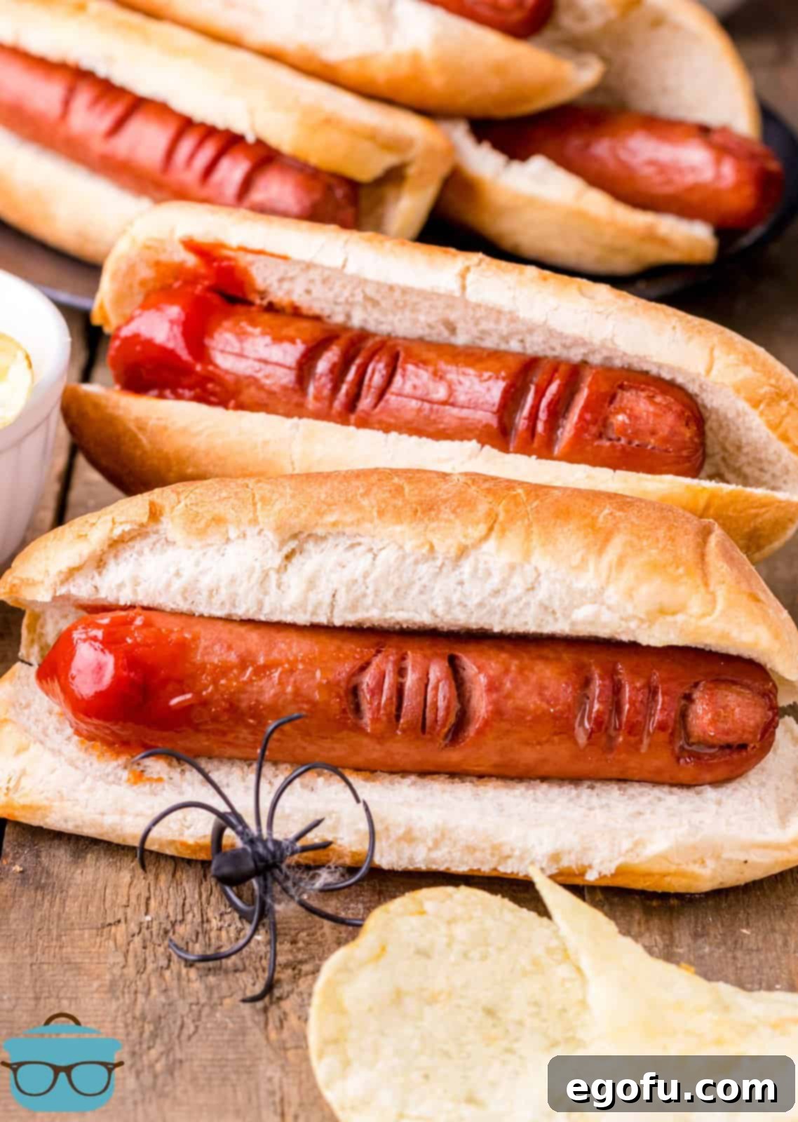 Halloween Hot Dog Fingers in buns with chips and a fake spider.