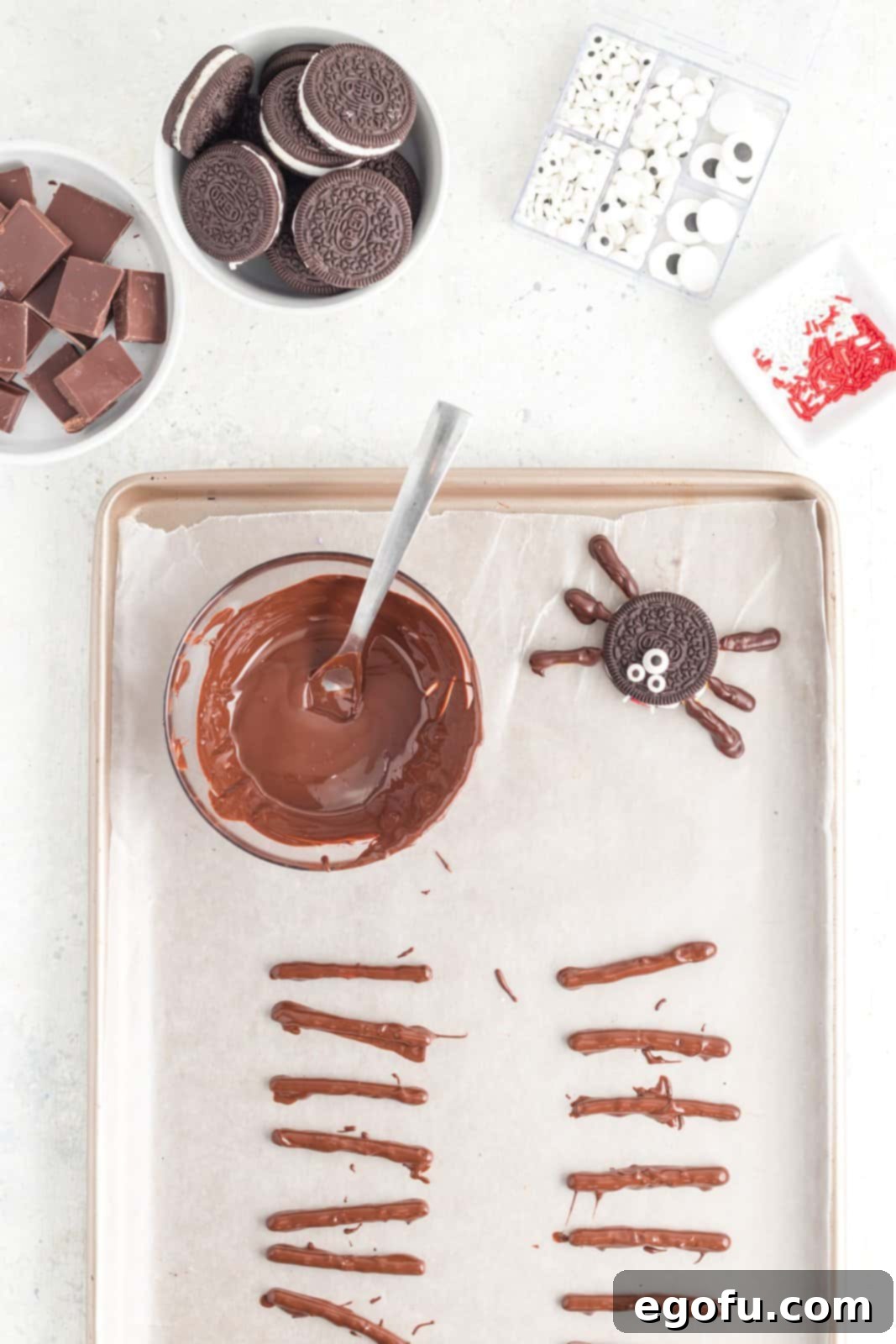 Spooktacular Oreo Spiders 7 Chocolate covered pretzels setting on parchment lined baking sheet.