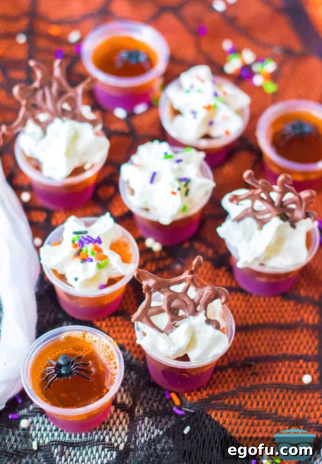 An inviting overhead shot of finished Hocus Pocus Jell-O Shots, showcasing their vibrant layers and festive decorations, ready for a Halloween celebration.
