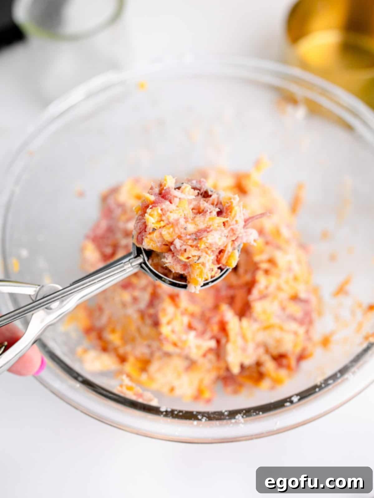 Cookie scoop scooping mixture out of bowl.