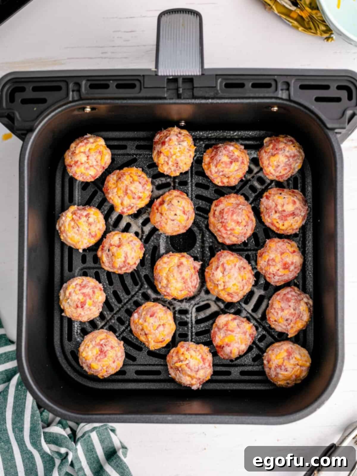 Rounded balls placed in air fryer basket.