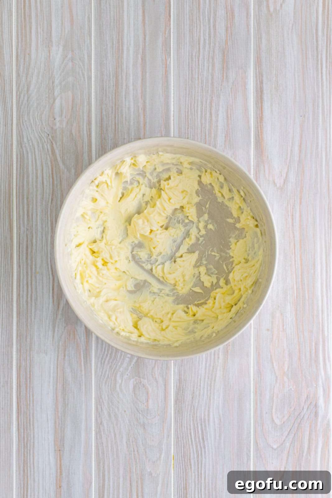 Butter and cream cheese beaten together in bowl.