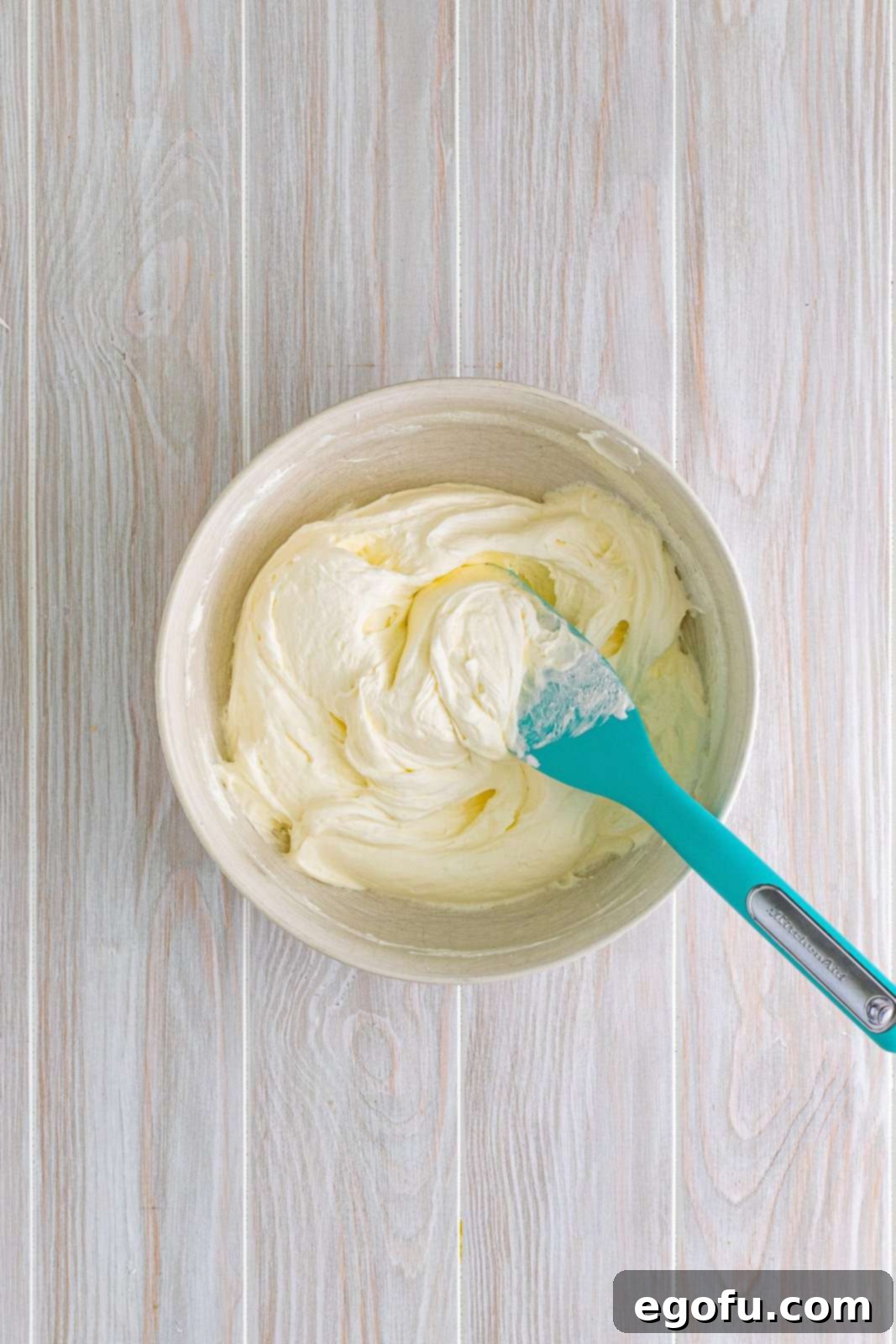 Powdered sugar and whipped topping added to cream cheese and butter mixture.