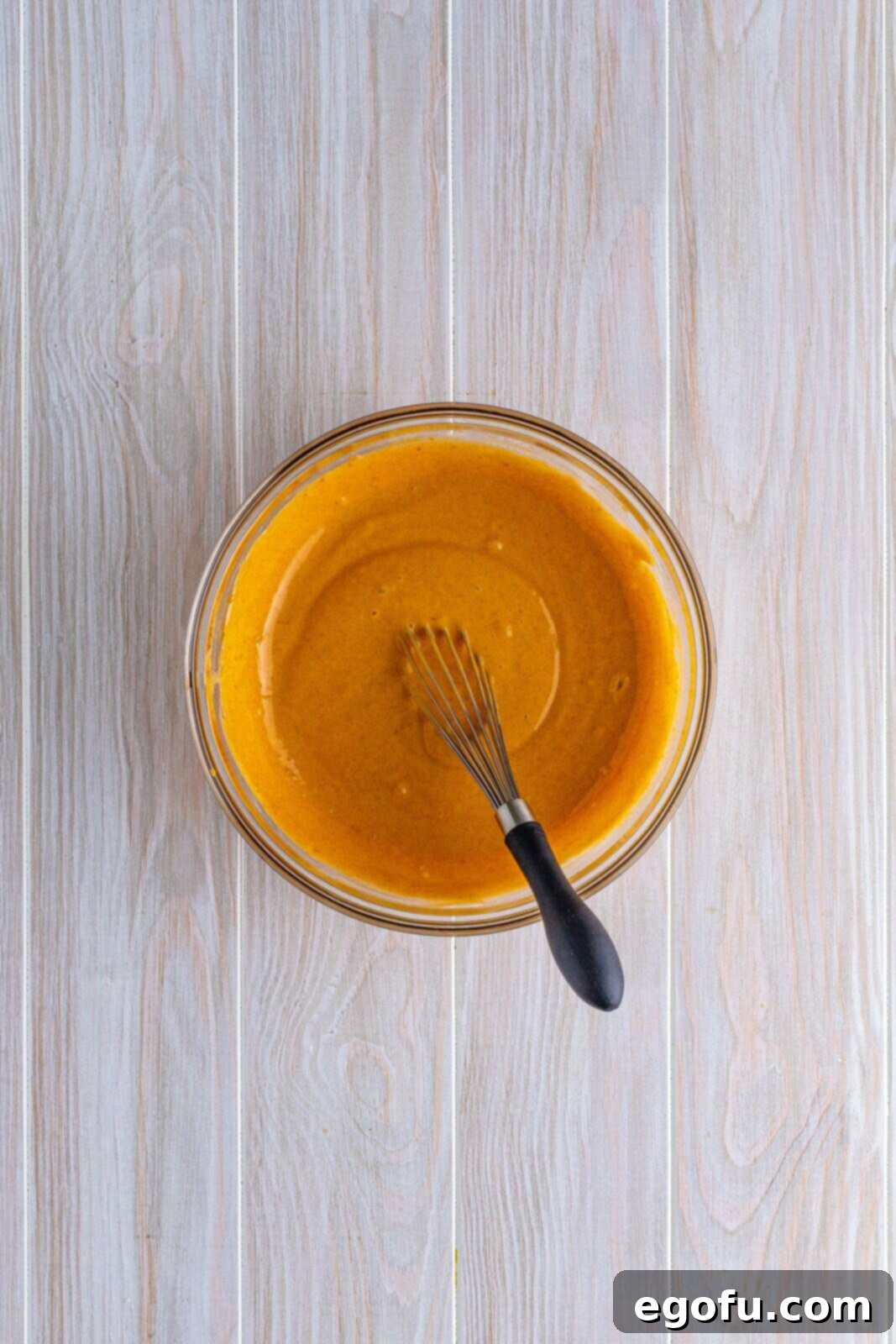 Pumpkin pudding whisked together in bowl.
