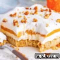 Close up square image of slice of Pumpkin Delight on white plate with bite taken out.