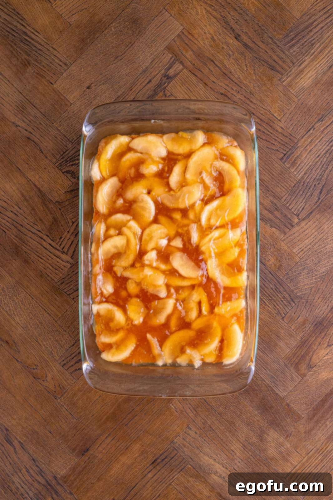 Classic Apple Crumble Bars 12 A generous layer of sweet apple pie filling is smoothly spread over the pre-baked crust in the pan, ready for the final crumble topping.