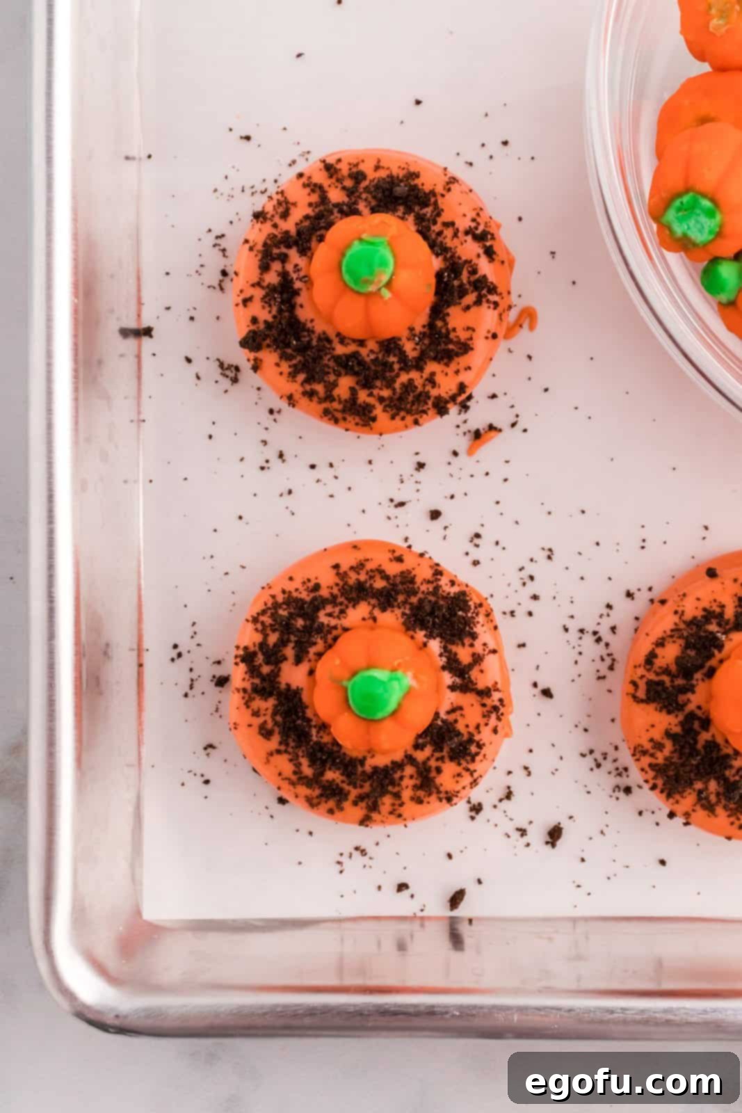 Spiced Pumpkin Patch Cookies 10 Cookies topped with pumpkin candies on a parchment-lined baking sheet, completing the pumpkin patch design.
