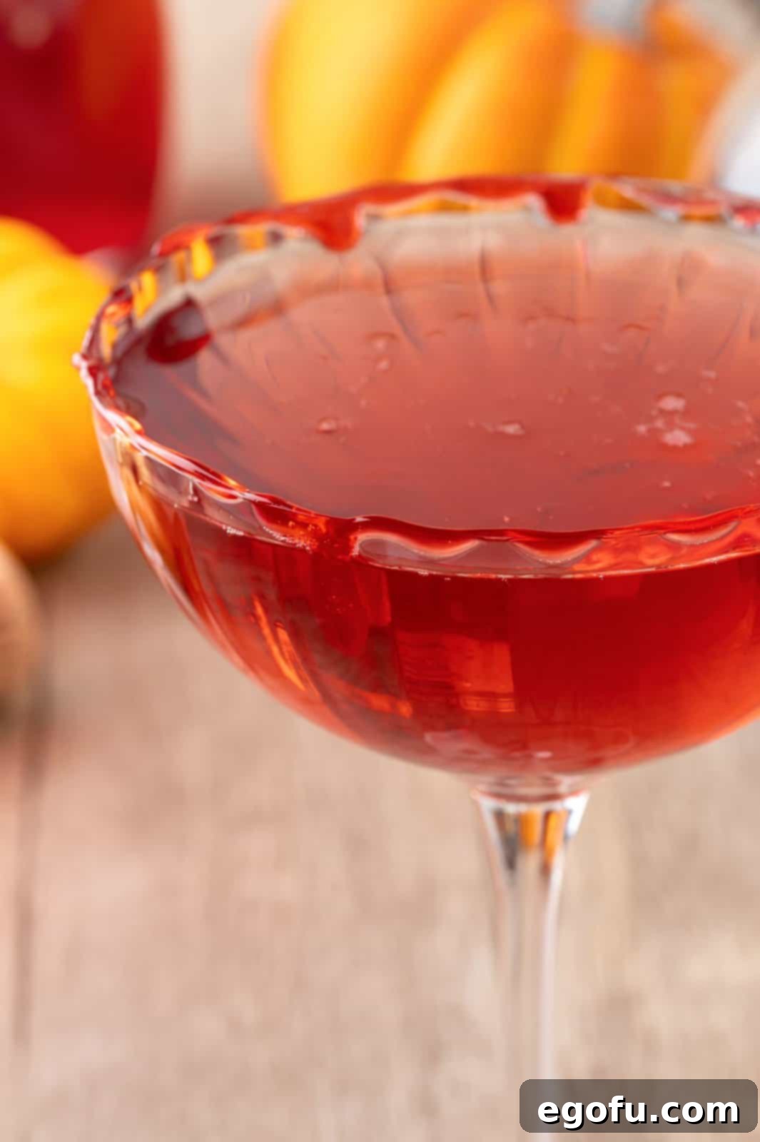 Crimson Embrace Elixir 10 Close-up of a finished Vampire's Kiss Cocktail in a martini glass, highlighting the red decorating gel rim and the vibrant red liquid.