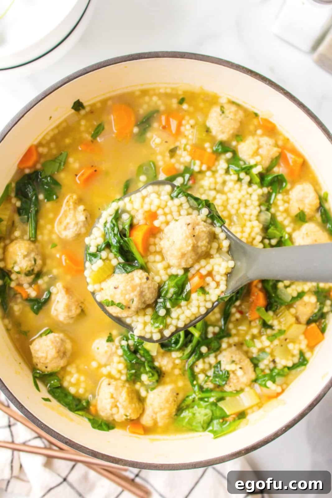 Italian Celebration Soup 2 Ladle holding up some of the Italian Wedding soup from dutch oven.