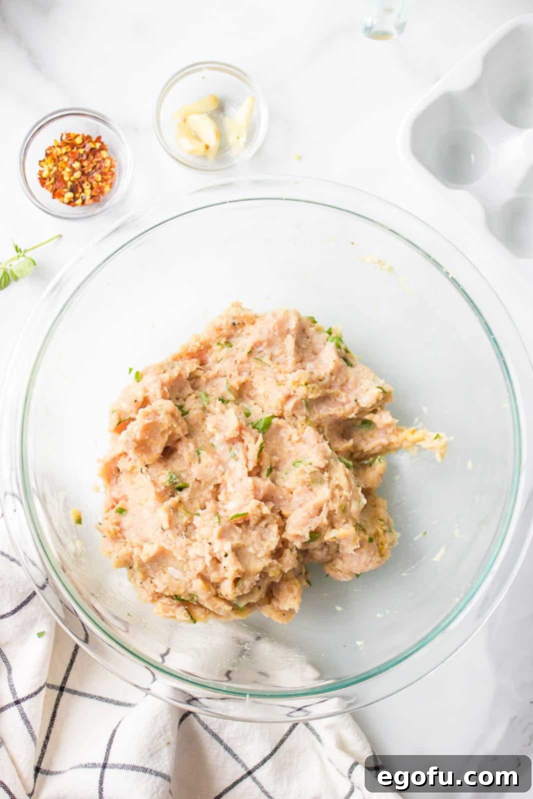 Italian Celebration Soup 5 Ground chicken, fresh parsley, fresh oregano, egg, breadcrumbs, salt, pepper, and garlic mixed together in bowl.