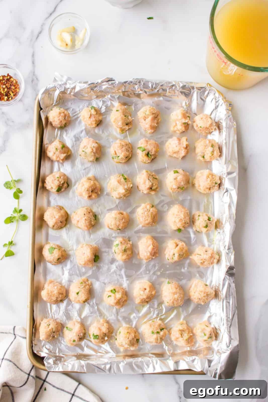 Italian Celebration Soup 6 Meat mixture shaped into meatballs and placed on a foil lined baking sheet.