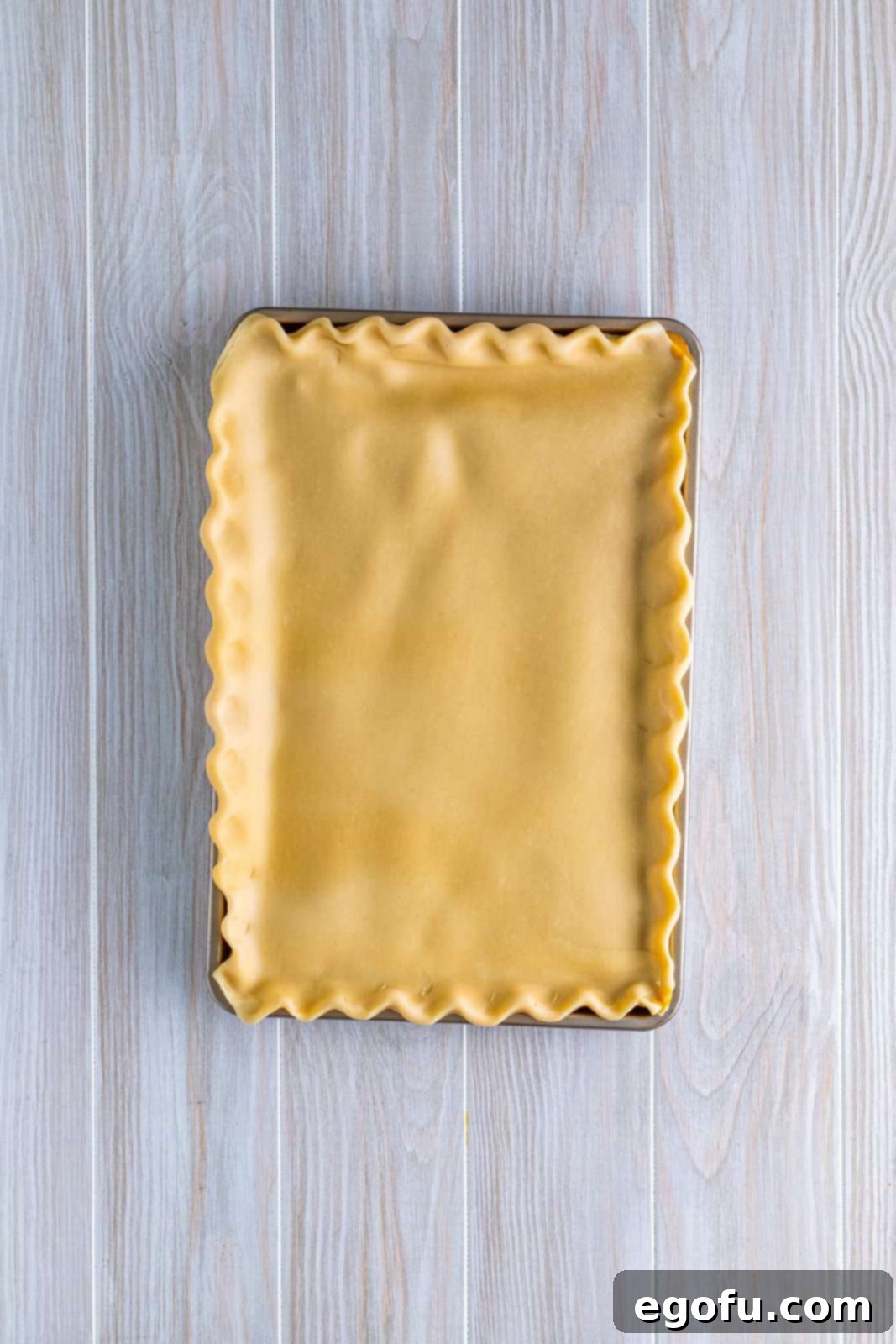 Top pie crust added and crimped together fluting the edges.