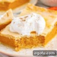 Close up square image of a slice of Pumpkin Slab Pie with bite taken out of it, garnished.