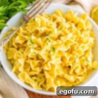 Campus Noodle Comfort 9 A bowl of creamy Cafeteria Noodles with a fork ready to be enjoyed.