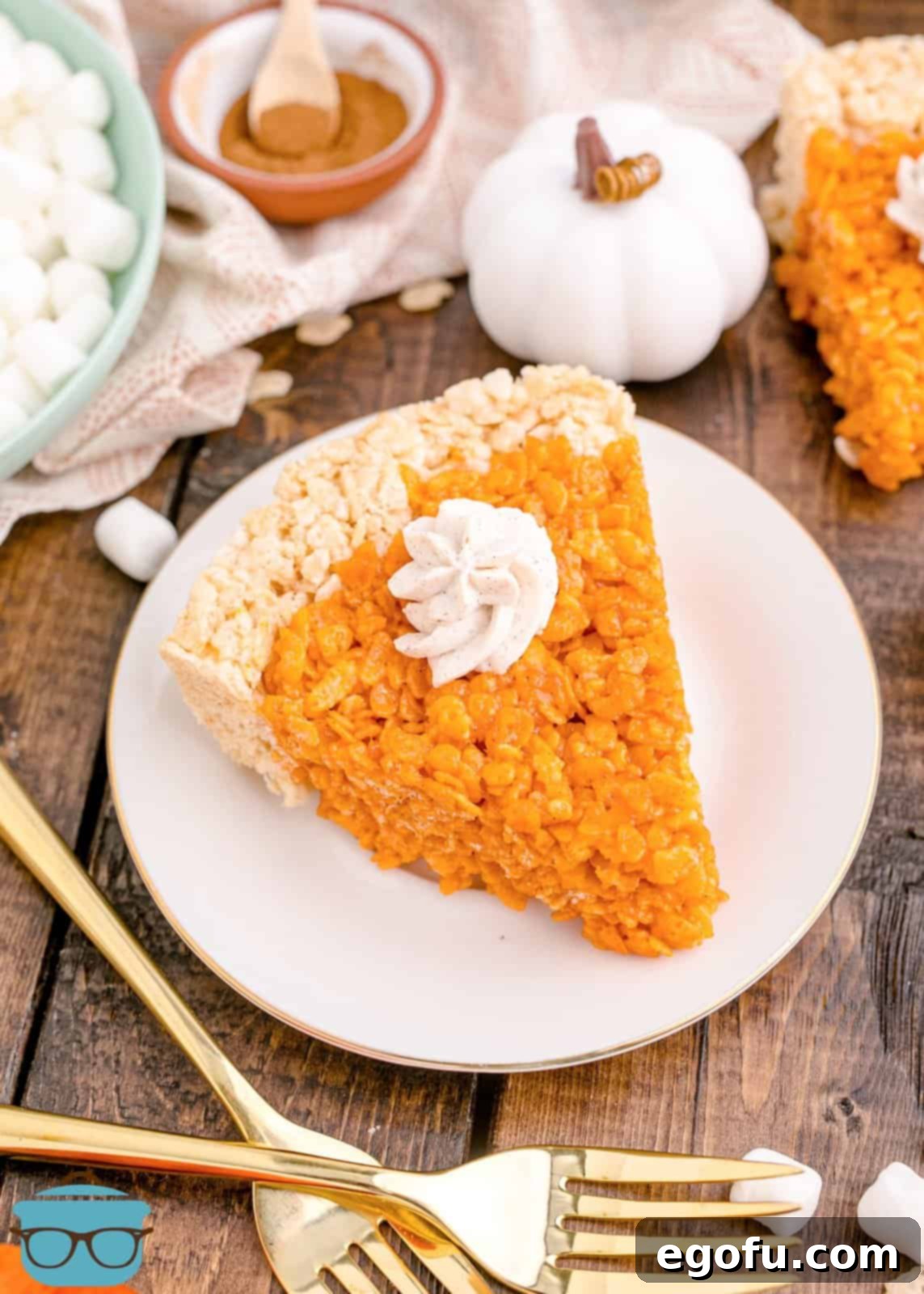 On slice of the Pumpkin Pie Rice Krispies Treats on white plate topped with whipped cream.