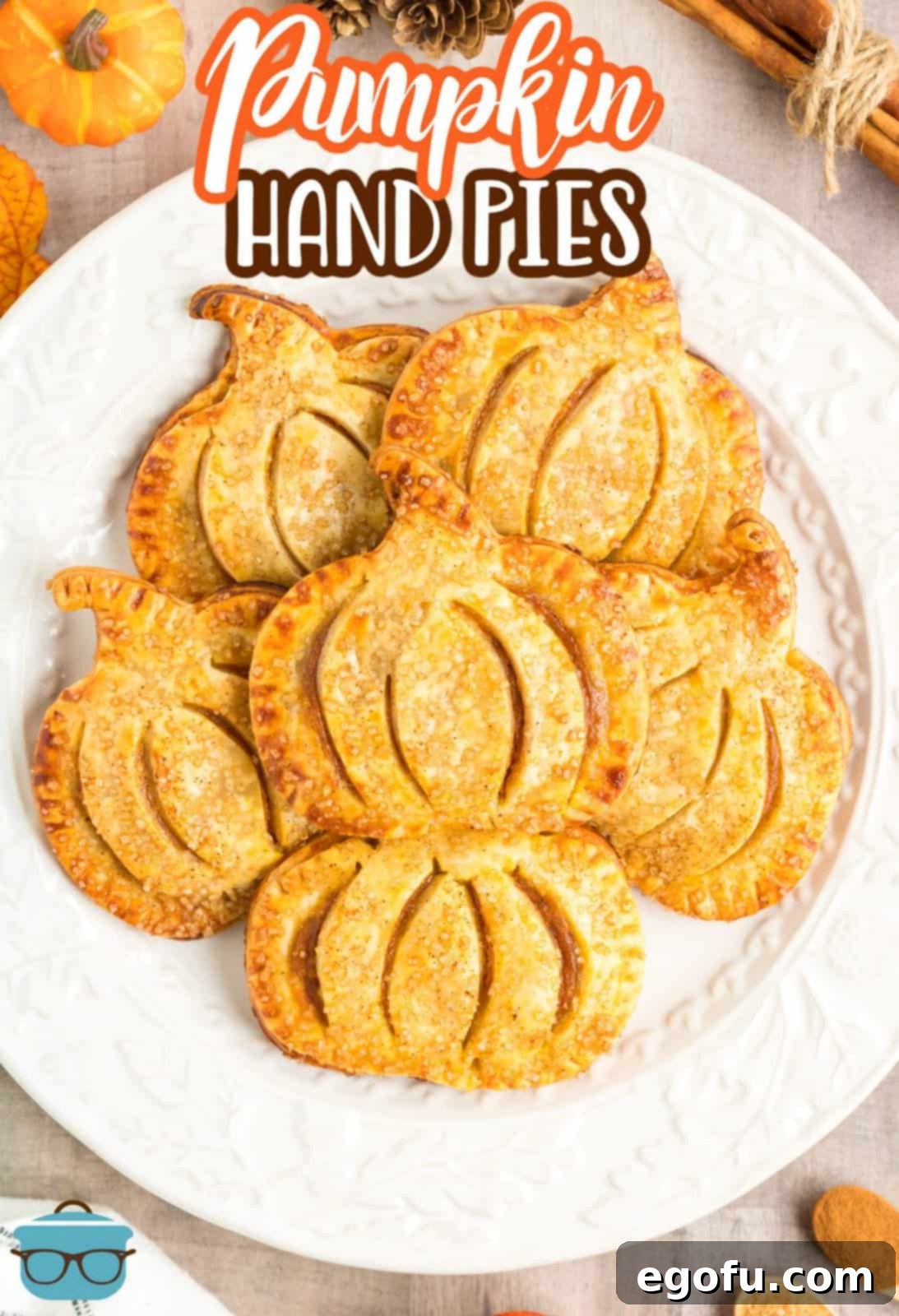 Pinterest image overhead of Pumpkin Hand Pies stacked on white plate.