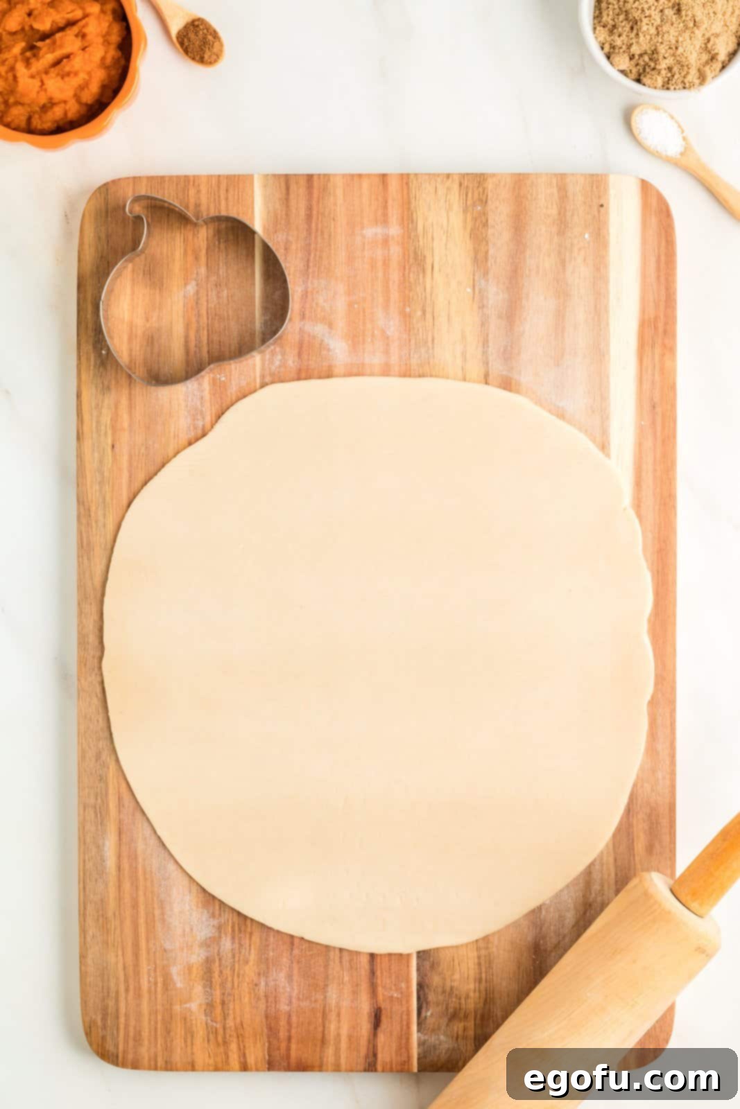 One pie crust rolled out on cutting board.