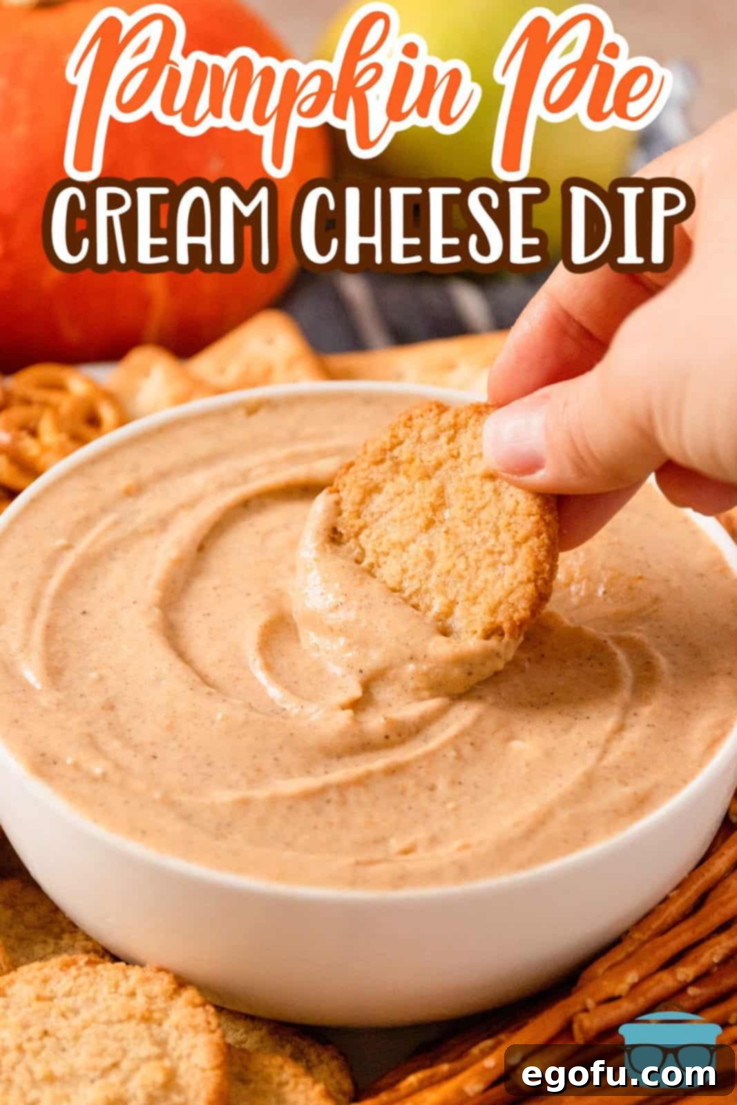 Pinterest image of hand dipping a cookie into the Pumpkin Dip in bowl.