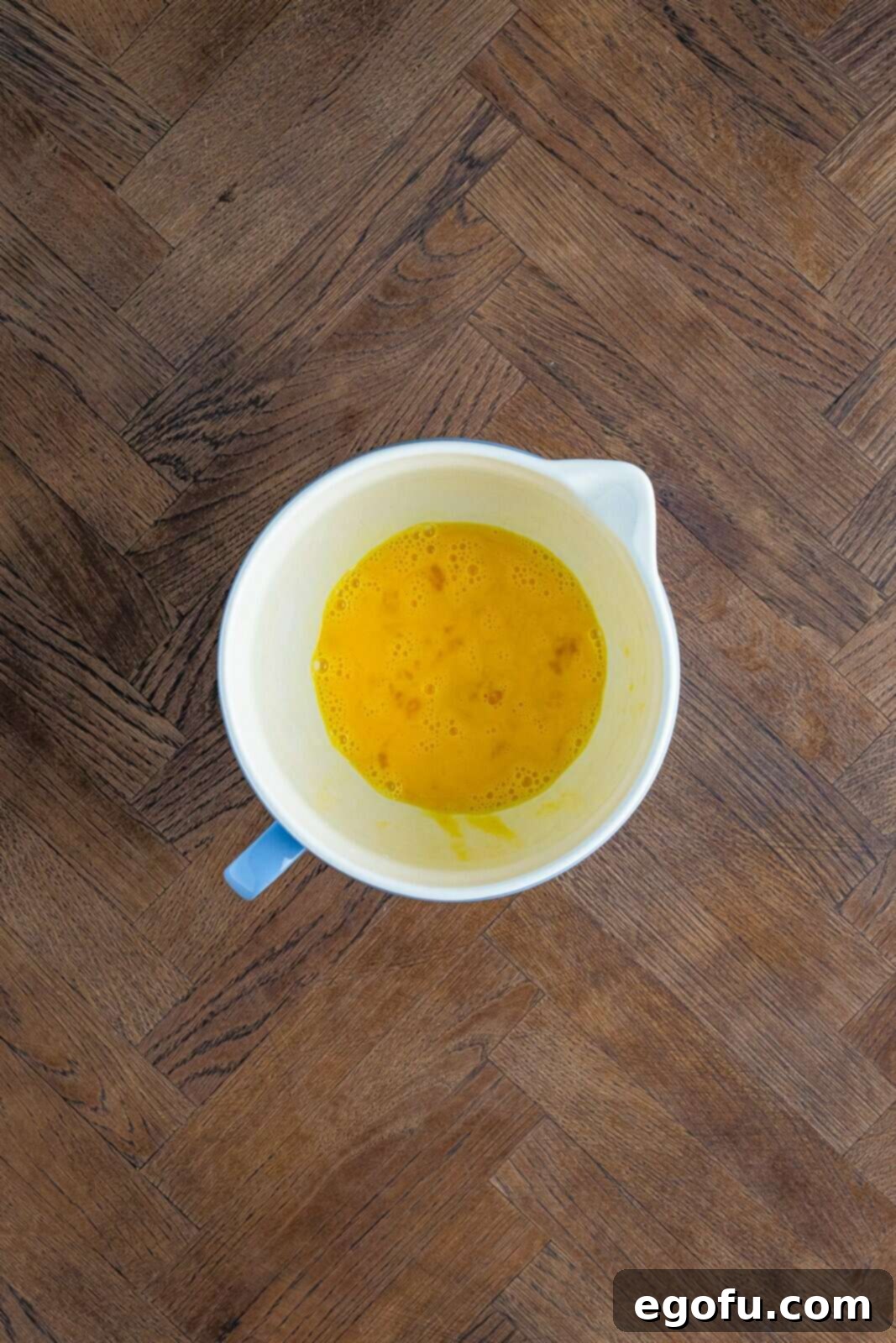 Eggs whisked together in bowl.