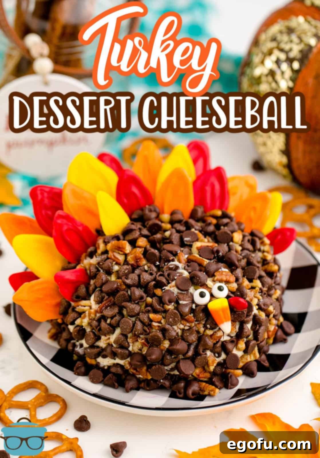 Beautiful Turkey Dessert Cheeseball on a checkered plate, surrounded by dippers like pretzels, showcasing its festive appeal.