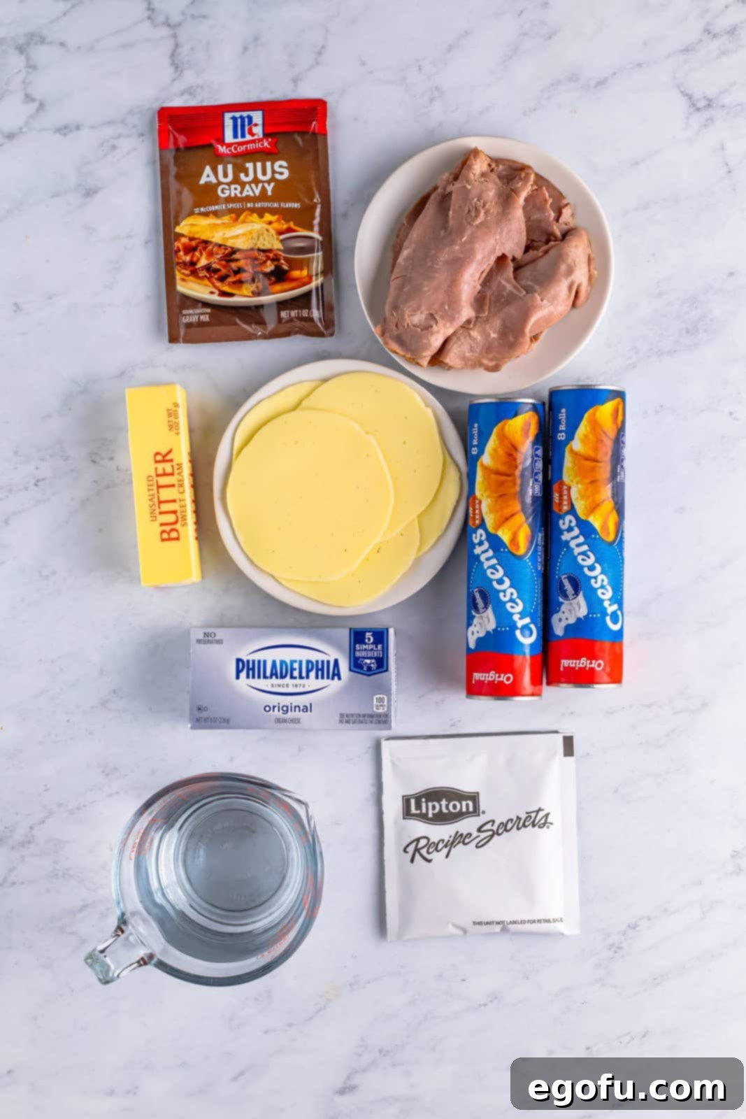 Ingredients needed: deli-sliced roast beef, cream cheese, deli-sliced provolone cheese, onion soup mix, crescent roll dough, unsalted butter, au jus gravy mix, cold water and parsley, optional.