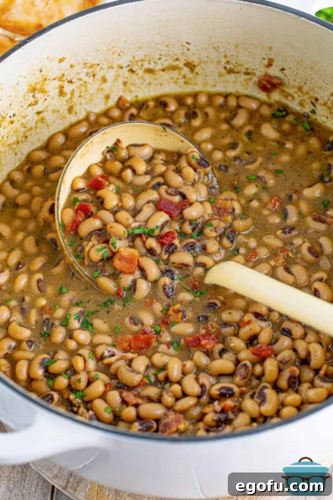 Down South Black Eyed Peas 7 Ladle in dutch oven with finished Southern Black Eyed Peas.