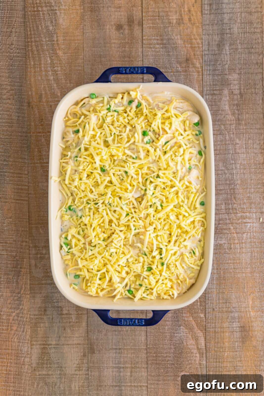 Mixture added to prepared baking dish with cheese sprinkled on top.