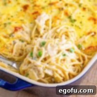 Close up square image of Easy Chicken Tetrazzini in baking dish with serving spoon pulling some out.