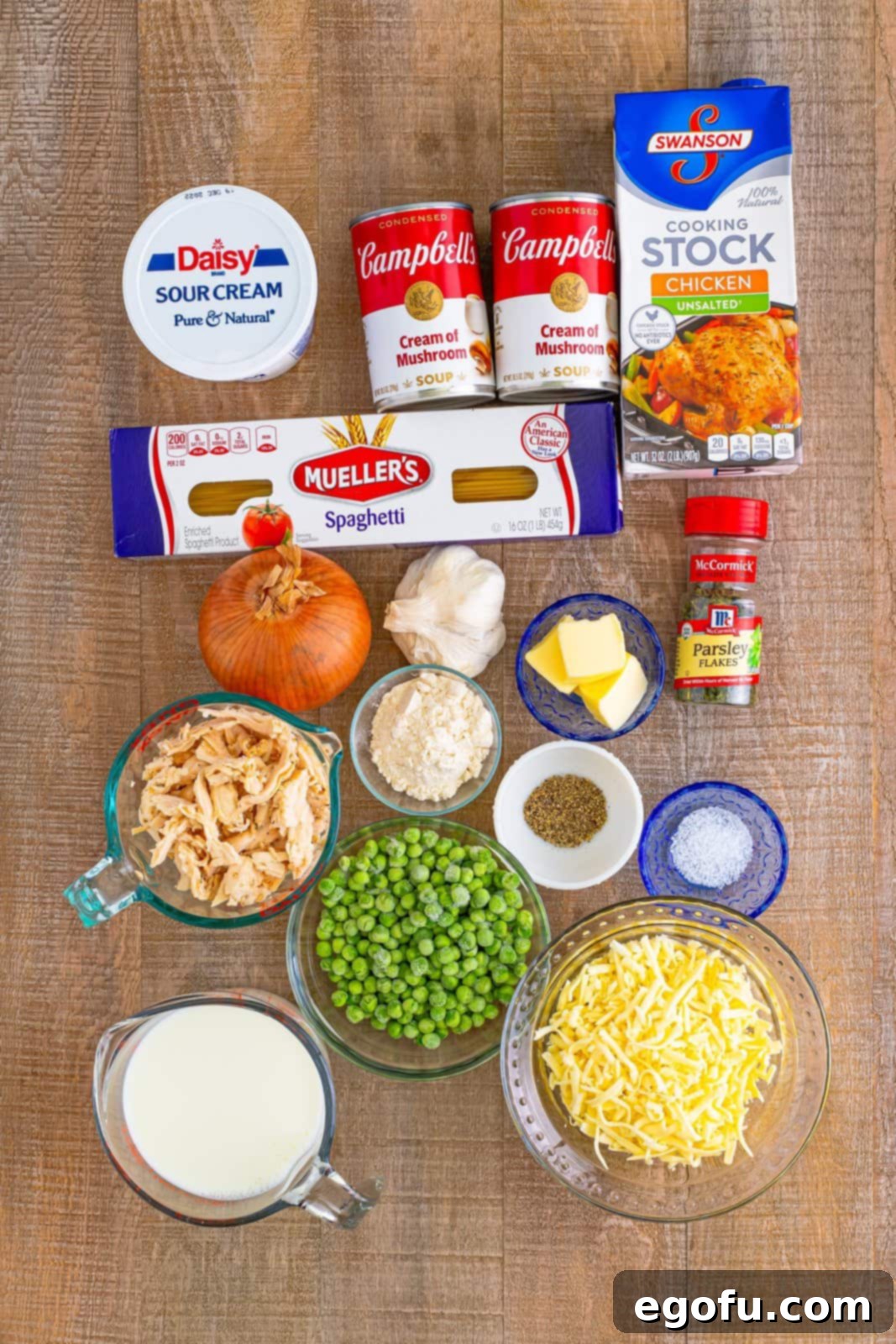 Ingredients needed: spaghetti noodles, salted butter, sweet onion, garlic, all-purpose flour, milk, unsalted chicken stock, cream of mushroom soup, shredded cooked chicken, frozen peas, sour cream, dried parsley flakes, kosher salt, pepper and shredded mozzarella cheese.