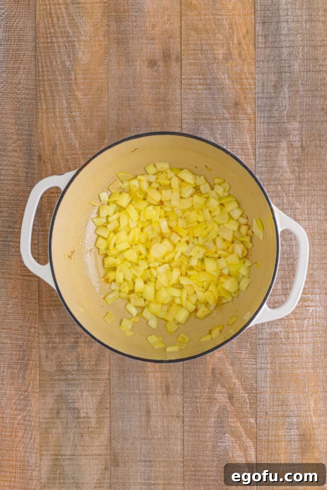 Onions being cooked in dutch oven.