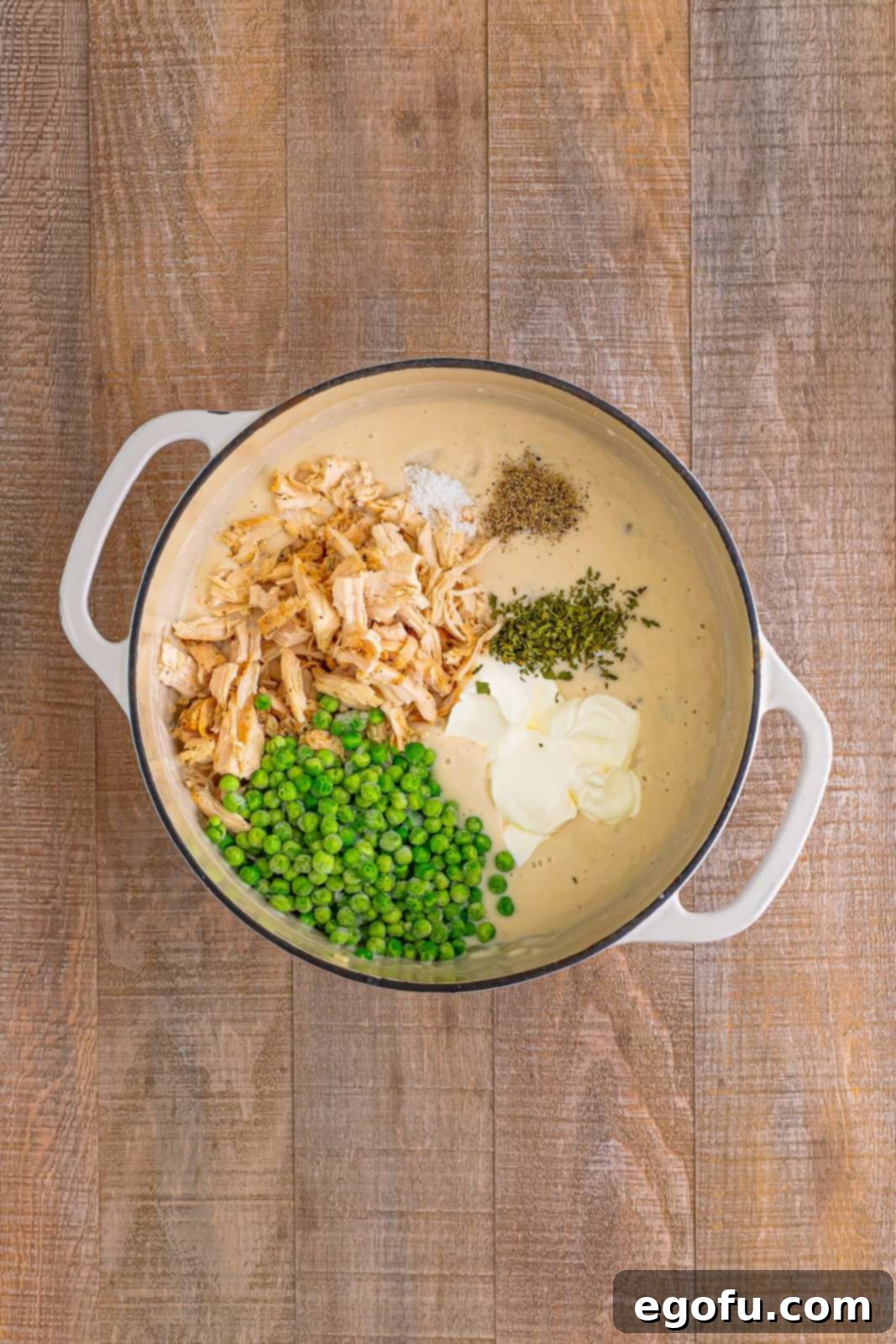 Chicken, peas, sour cream, dried parsley, salt, and pepper added to the dutch oven.