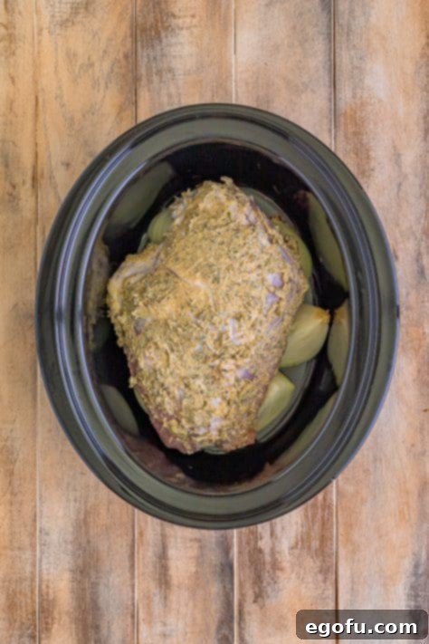 Butter covered turkey breast added on top of onions in crock pot.