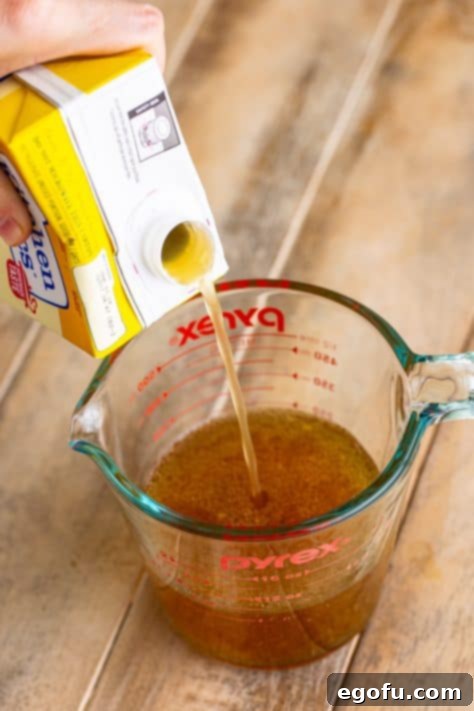 stock being added to drippings in measuring cup.