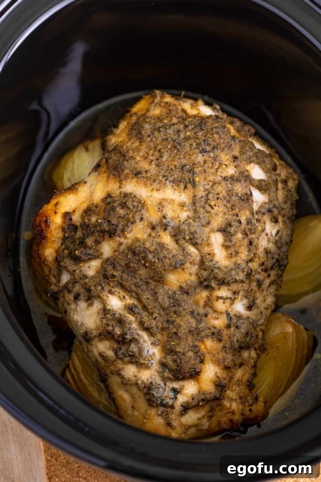 The perfectly cooked turkey breast, golden and tender, shown from an overhead view in the slow cooker after reaching its optimal internal temperature.