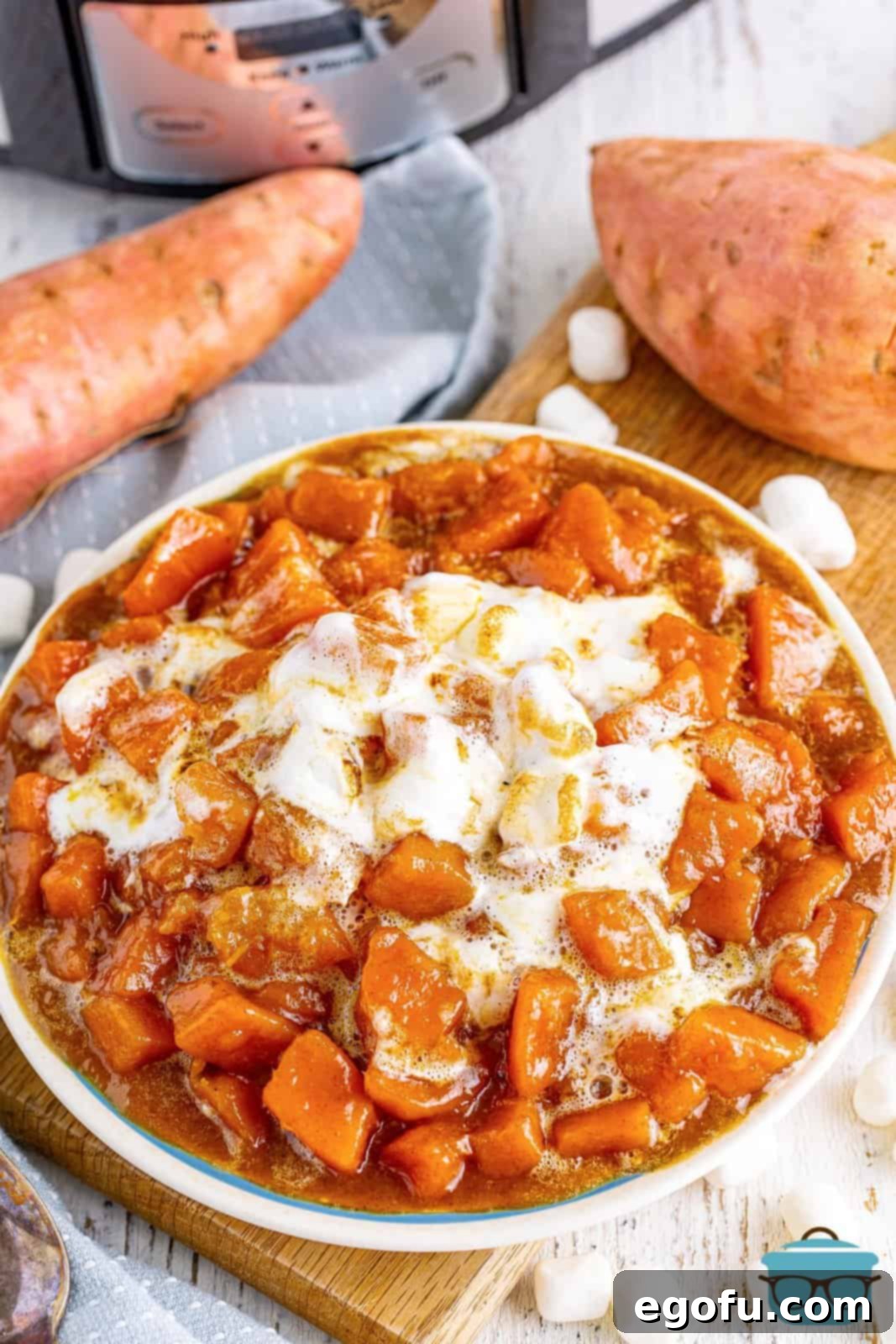 Crock Pot Candied Yams in a white bowl showing melted marshmallows.