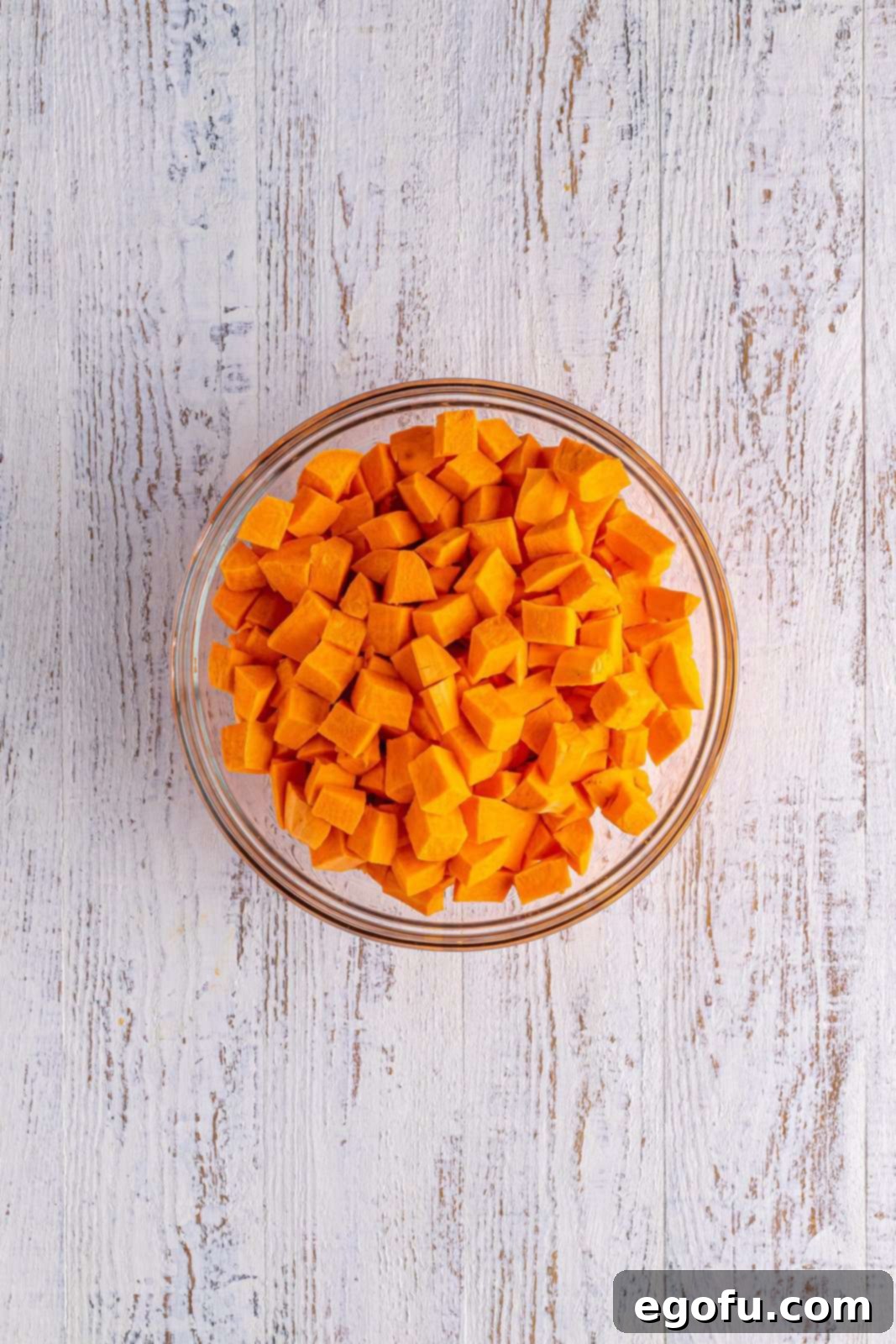 Diced sweet potatoes added to a bowl, ready for the sauce.