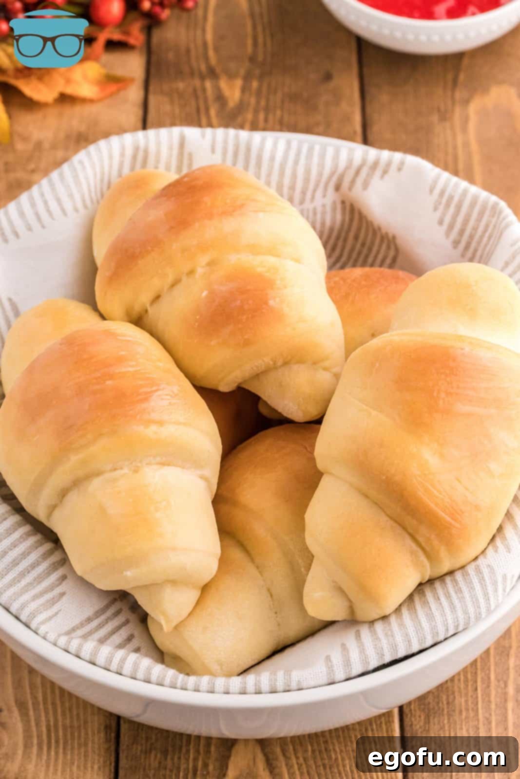 Overhead view of freshly baked Homemade Crescent Rolls artfully arranged in a linen-lined bowl.