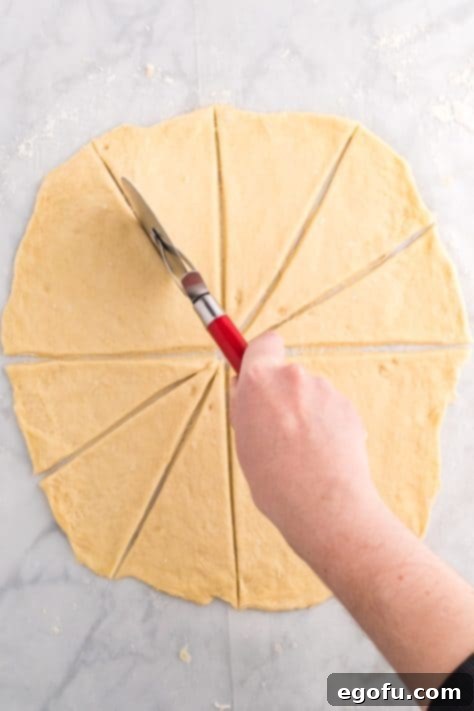 Dough being cut into 12 triangles.