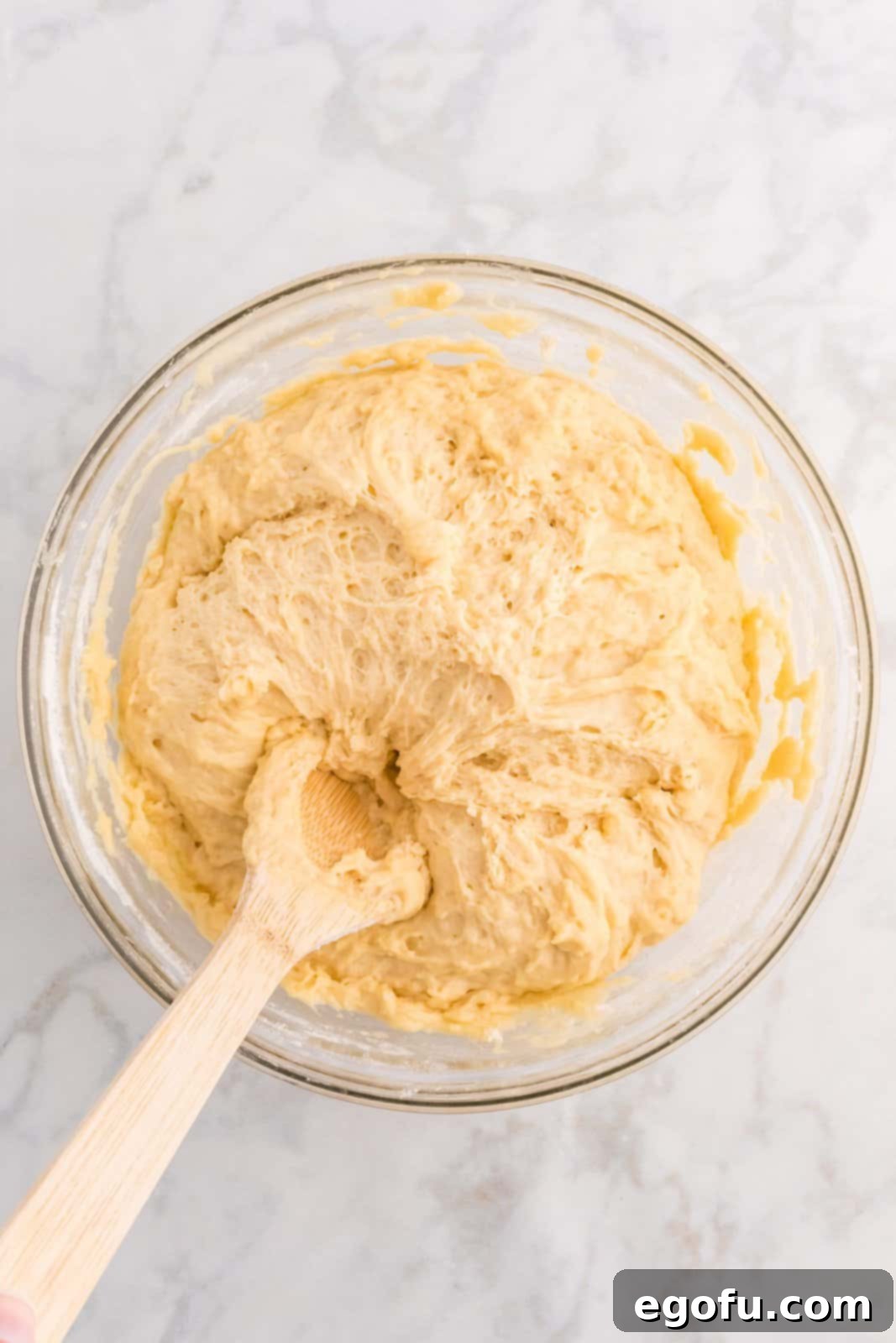 The dough after all flour has been incorporated, showing a smooth, cohesive, and sticky texture.