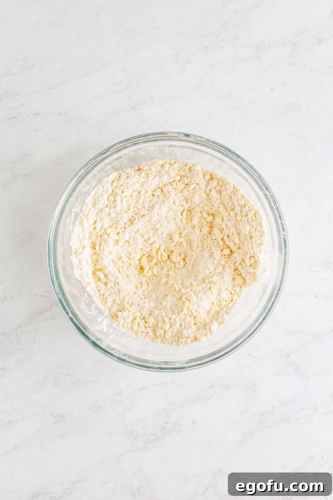 Hearty Turkey Pot Pie Delight 11 Butter cut into dry ingredients in bowl.