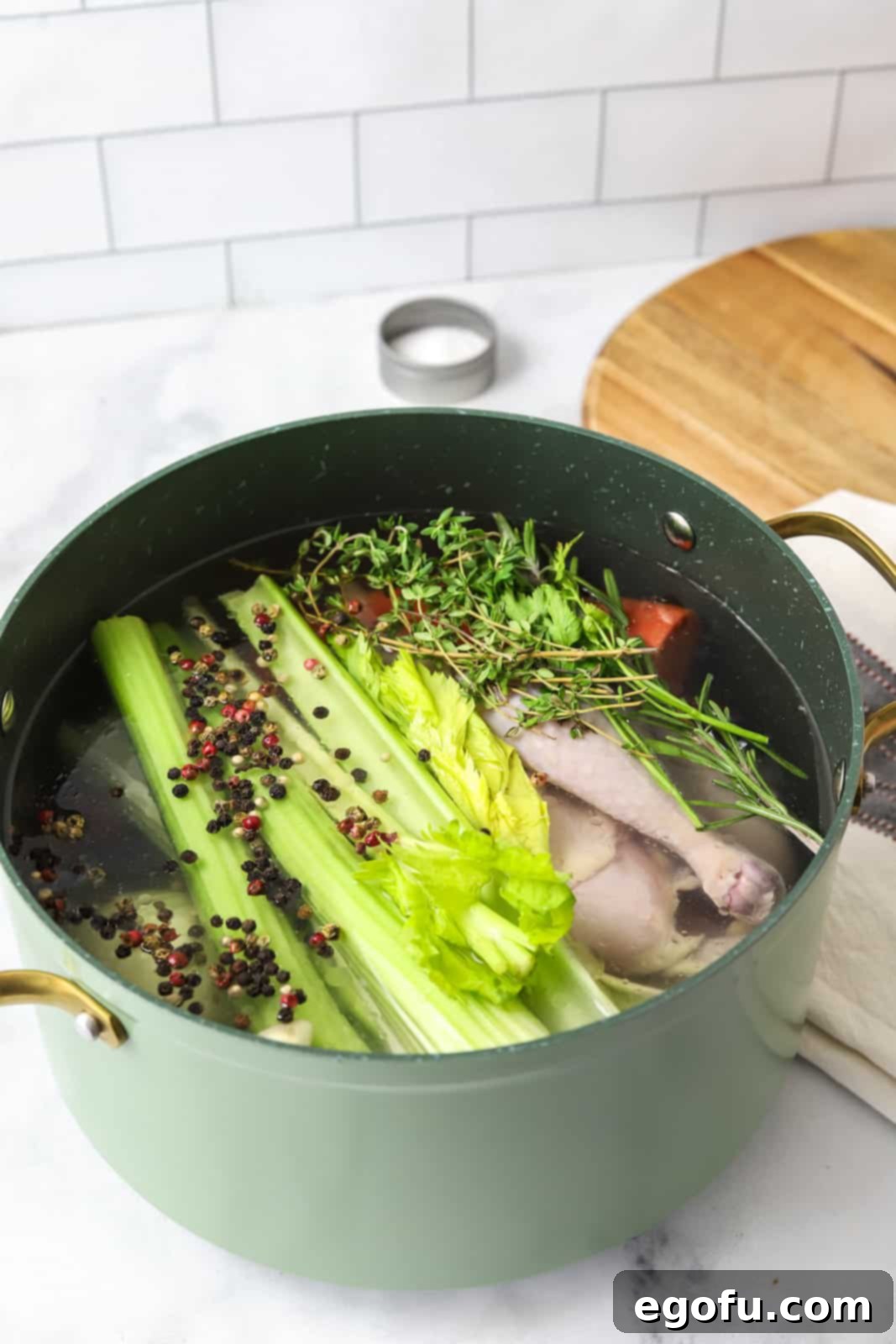 Water, rosemary, thyme, parsley, bay leaf, peppercorns and salt added to stock pot.