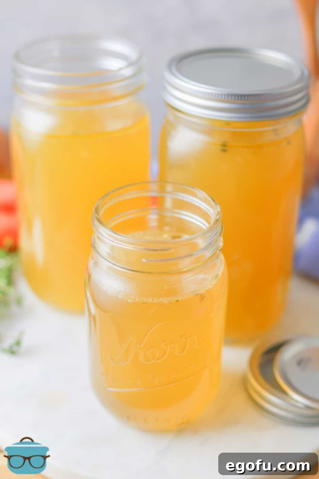 Homemade Chicken Broth in mason jars 2 with lids off.