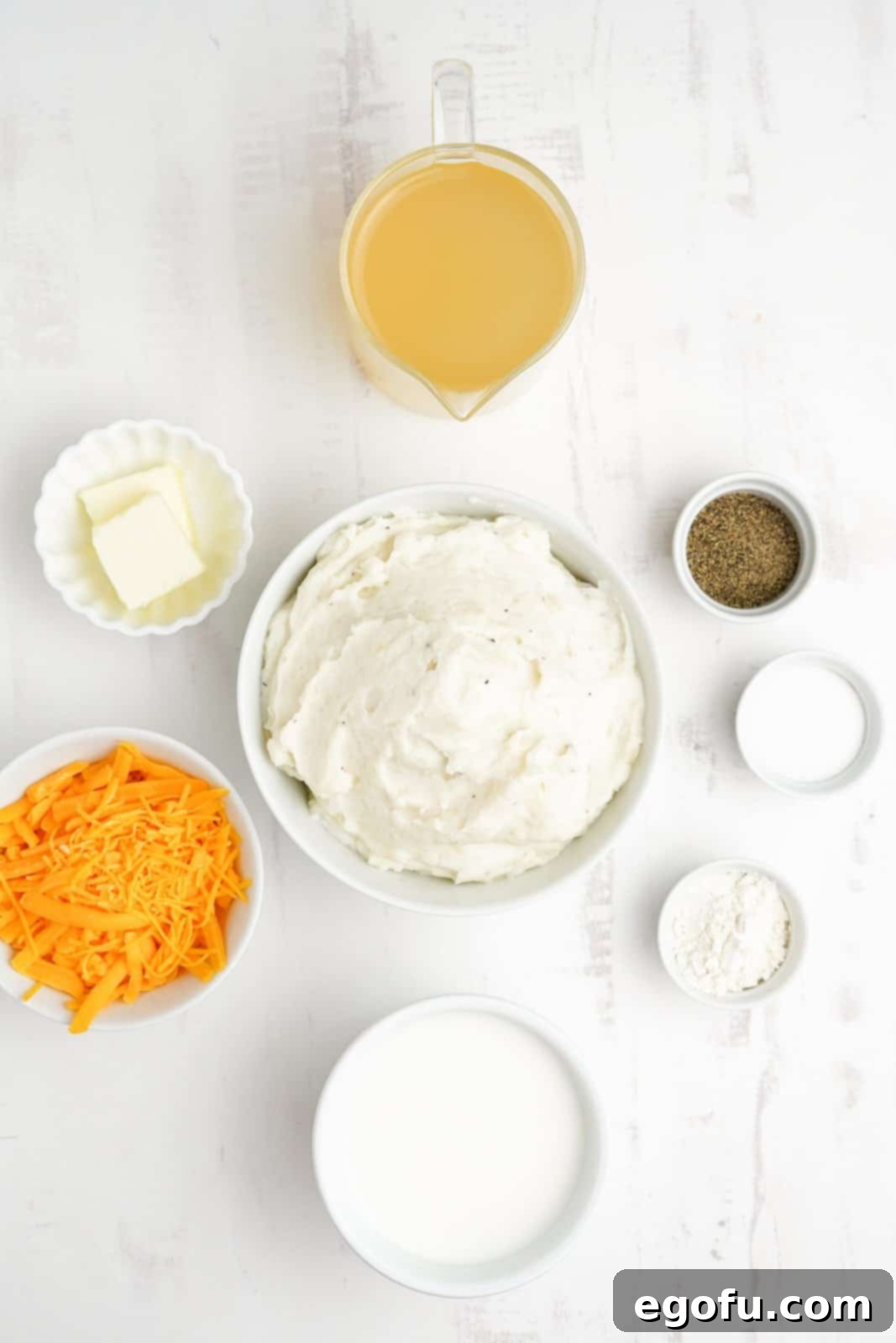 Ingredients needed for mashed potato soup, including butter, flour, salt, pepper, chicken broth, milk, mashed potatoes, and cheddar cheese.
