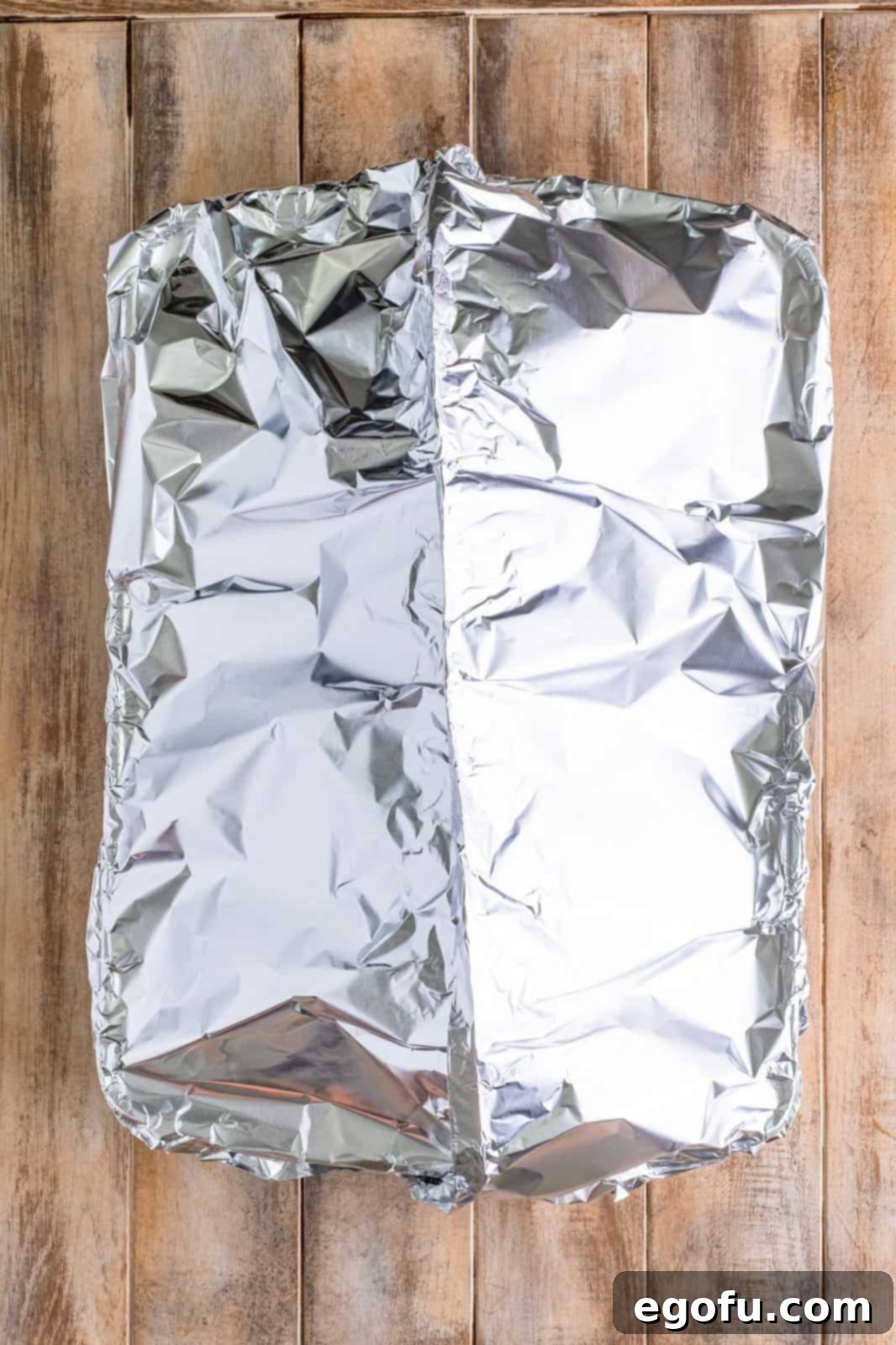 Mahogany Glazed Ham 11 The roasting pan with the ham covered loosely with aluminum foil, creating a tent.